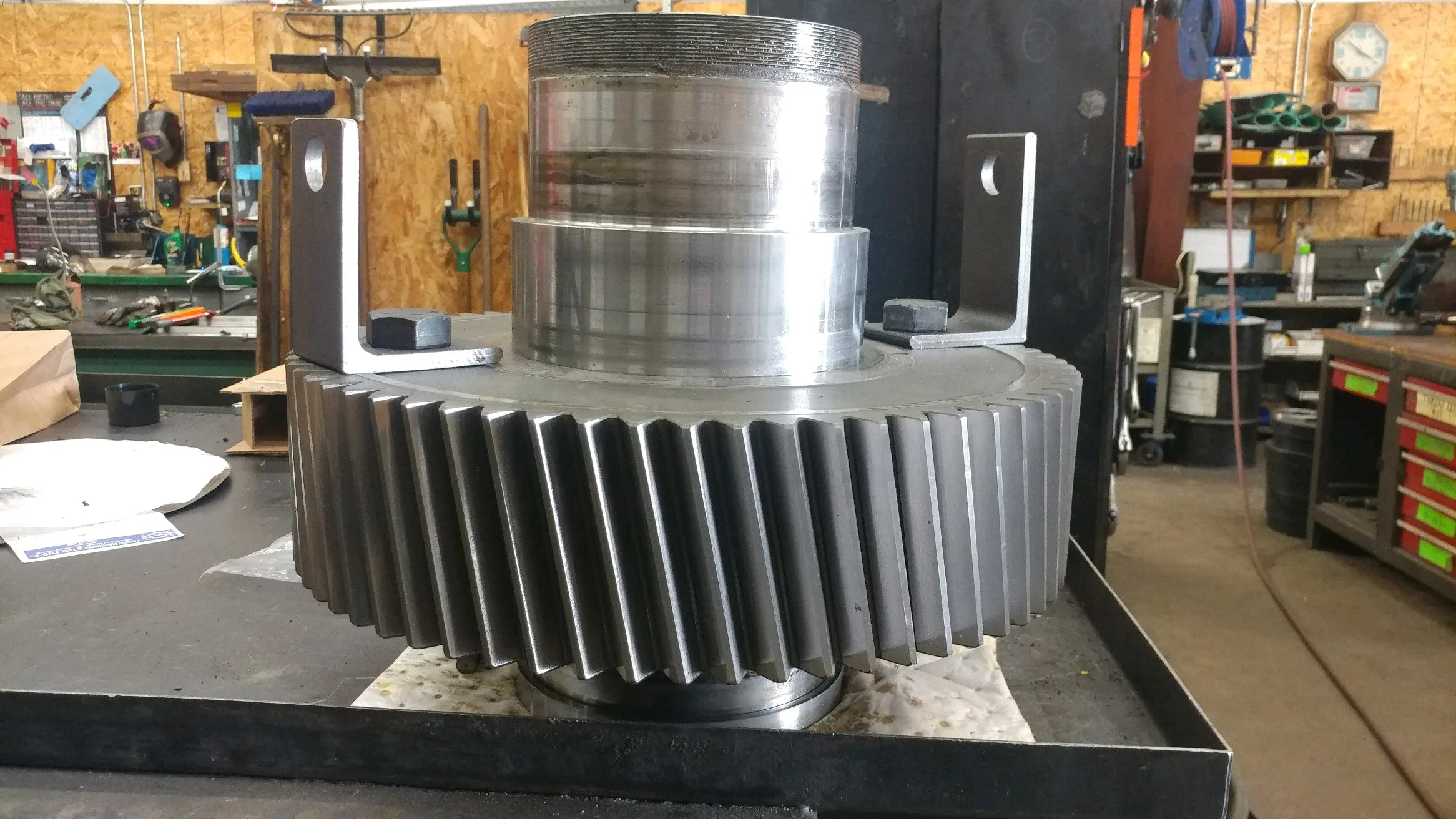 A large gear is on a table being prepared for service.